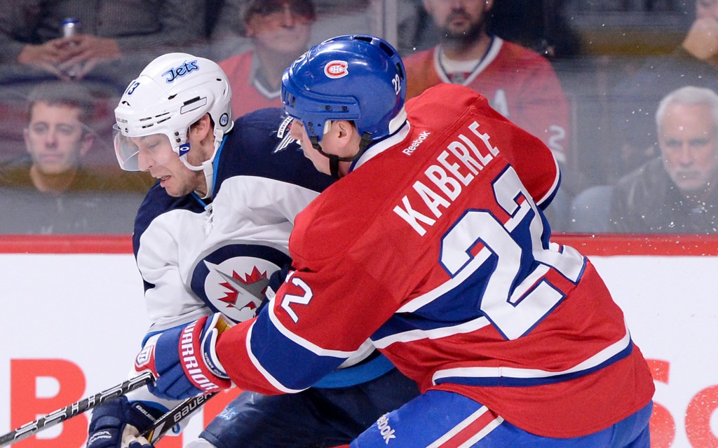 MONTREAL, CANADA - JANUARY 29: Anthony Peluso #14 of the Winnipeg Jets skates with the puck while being defended by Tomas Kaberle #22 of the Montreal Canadiens during the NHL game at the Bell Centre on January 29, 2013 in Montreal, Quebec, Canada. The Canadiens defeated the Jets 4-3. (Photo by Richard Wolowicz/Getty Images)