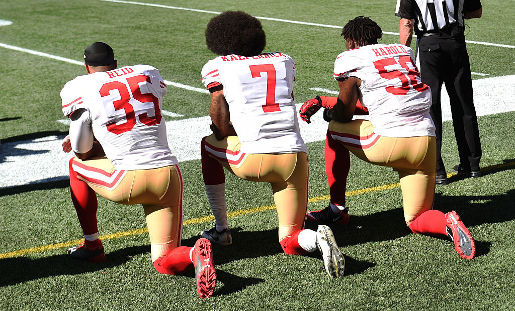 SEATTLE, WA - SEPTEMBER 25: (L-R) fFee safety Eric Reid #35, quarterback Colin Kaepernick #7  and outside linebacker Eli Harold #58 of the San Francisco 49ers kneel on the sidelines during the national anthem before the game against the Seattle Seahawks at CenturyLink Field on September 25, 2016 in Seattle,Washington. (Photo by Steve Dykes/Getty Images)