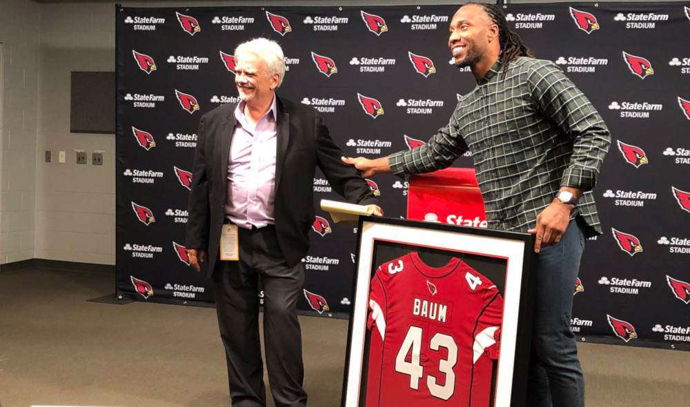 Larry Fitzgerald presenting Bob Baum with a jersey.