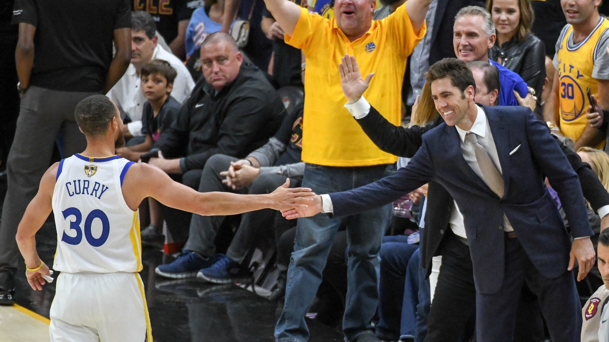 Steph Curry high-fives Warriors GM Bob Myers