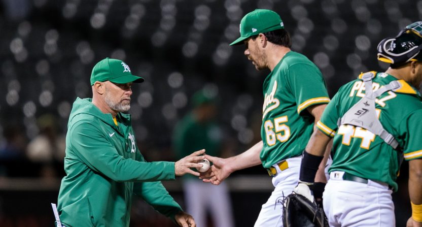 Oakland Athletics relief pitcher Trevor May (65) is lifted by manager Mark Kotsay (7) during the eighth inning