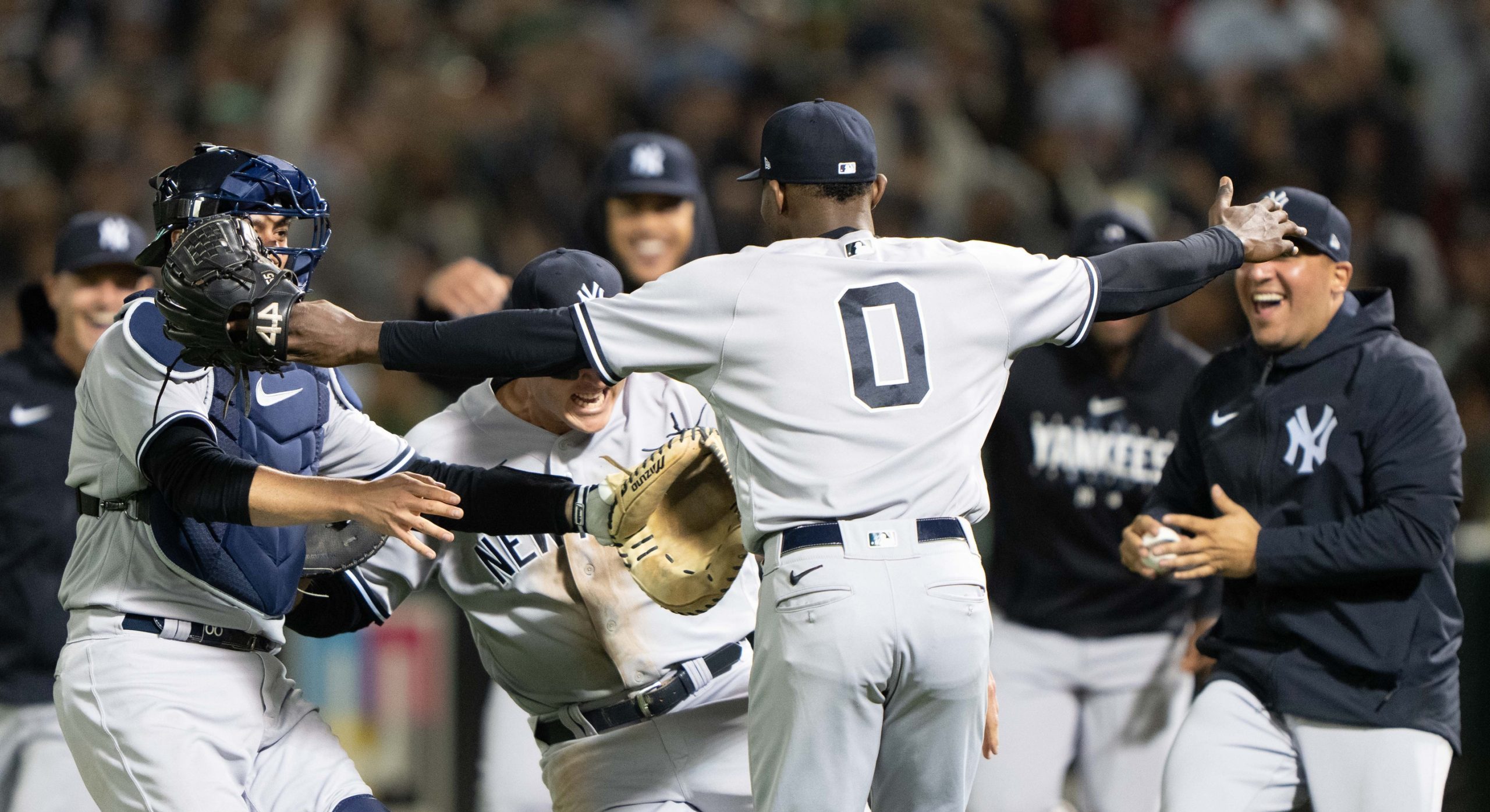 Domingo German's teammates rush him after throwing a perfect game against the Athletics.
