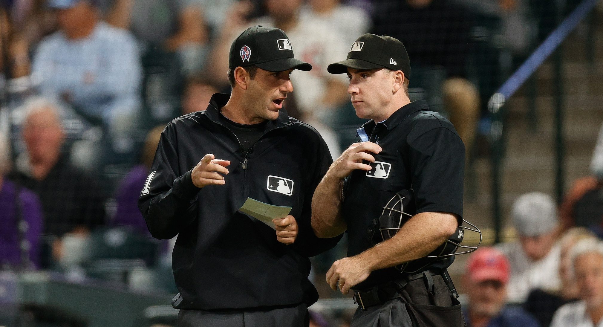 Umpires meeting at home plate after the premature exit of umpire Brian O'Nora