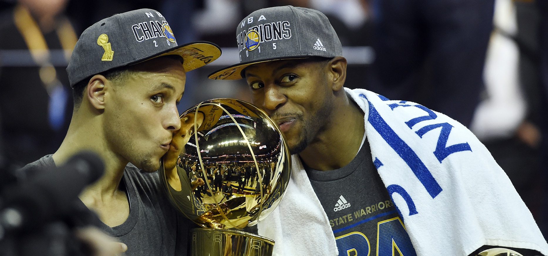 Jun 16, 2015; Cleveland, OH, USA; Golden State Warriors guard Stephen Curry (30) poses with the Larry O'Brien Trophy as Golden State Warriors guard Andre Iguodala (9) celebrates with the NBA Finals MVP trophy after beating the Cleveland Cavaliers in game six of the NBA Finals at Quicken Loans Arena. Mandatory Credit: Bob Donnan-USA TODAY Sports