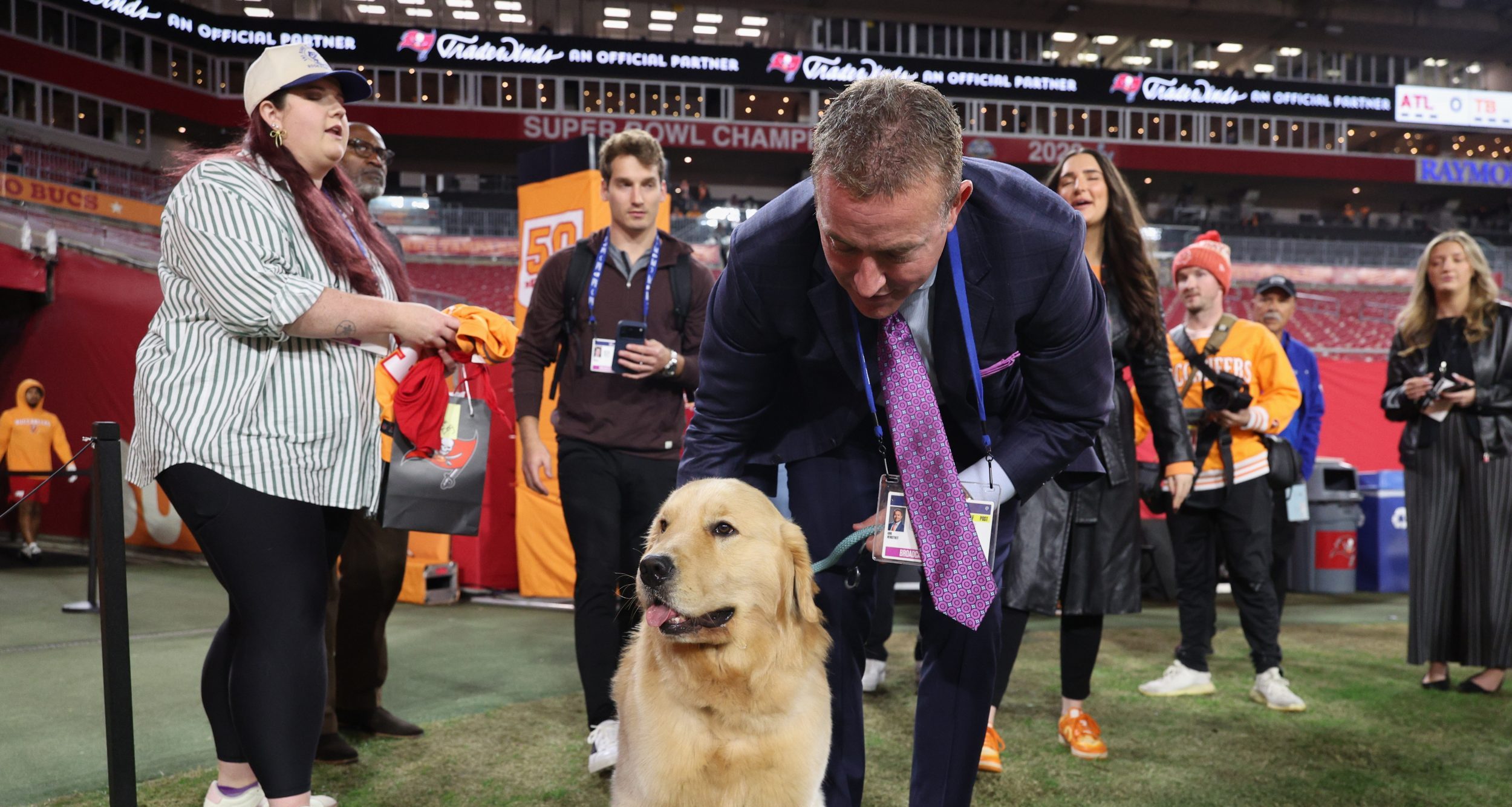 Kirk Herbstreit and his dog Peter on the field before a game.