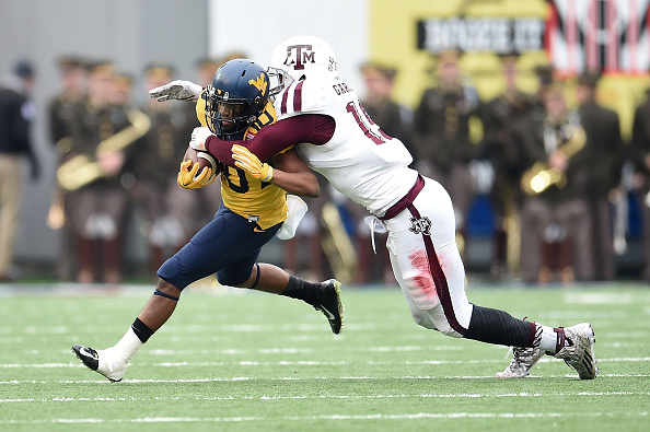 MEMPHIS, TN - DECEMBER 29:  Jordan Thompson #10 of the West Virginia Mountaineers is brought down by Myles Garrett #15 of the Texas A&M Aggies during the 56th annual Autozone Liberty Bowl at Liberty Bowl Memorial Stadium on December 29, 2014 in Memphis, Tennessee.  Texas A&M won the game 45-37.  (Photo by Stacy Revere/Getty Images)