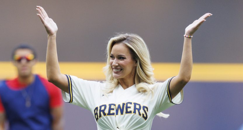 Paige Spiranac waves to the crowd after throwing out a first pitch prior to the game between the Pittsburgh Pirates and Milwaukee Brewers at American Family Field.