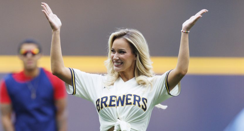 Paige Spiranac waves to the crowd after throwing out a first pitch