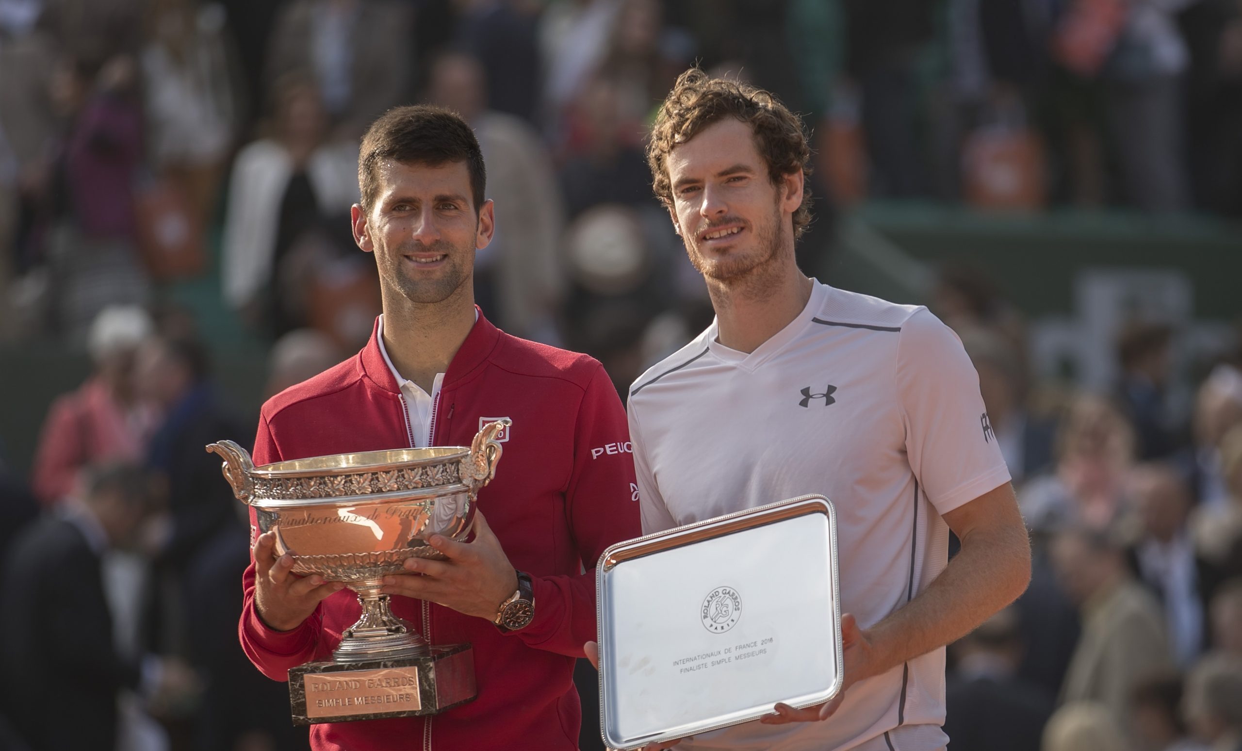 Tennis stars Novak Djokovic and Andy Murray hold trophies at the French Open.