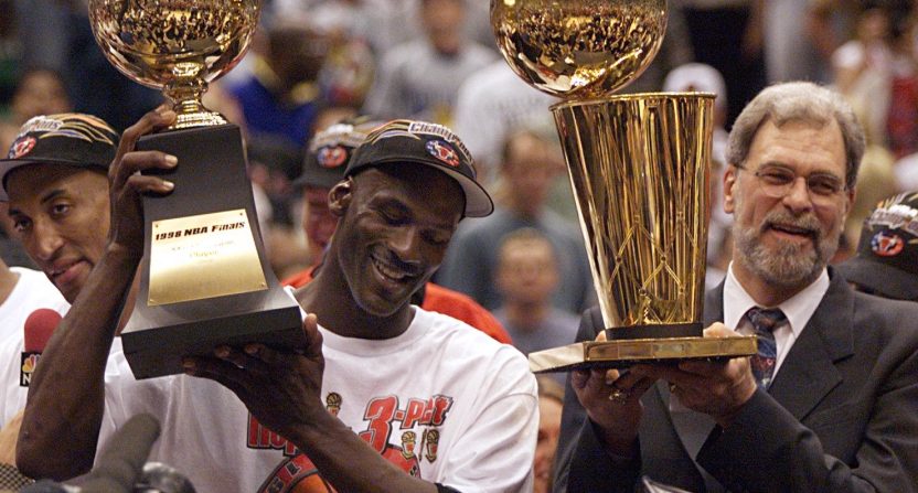 Michael Jordan and Phil Jackson holding trophies after the Chicago Bulls win the NBA title.