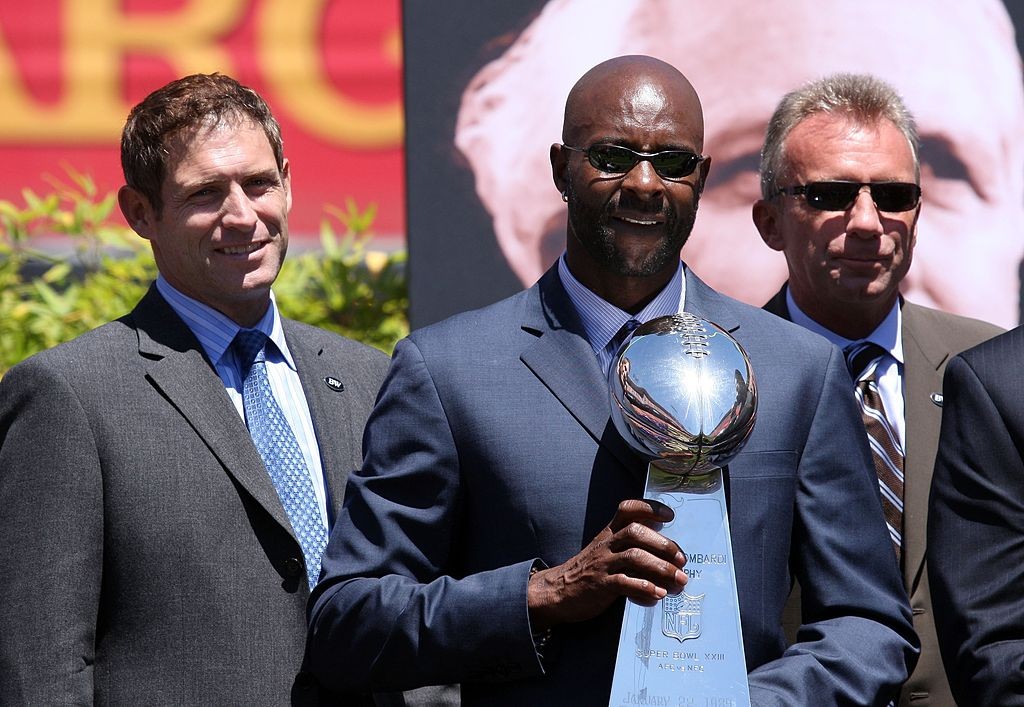 SAN FRANCISCO - AUGUST 10:  (L-R) Former San Francisco 49er players Steve Young, Jerry Rice and Joe Montana stand with a Super Bowl trophy during a public memorial service for former 49ers coach Bill Walsh August 10, 2007 at Monster Park in San Francisco, California. NFL Hall of Famer Bill Walsh, who was known by many as "The Genius" for leading the San Francisco 49ers to three Super Bowl championships, died last week at the age of 75 after a long battle with leukemia.  (Photo by Justin Sullivan/Getty Images)