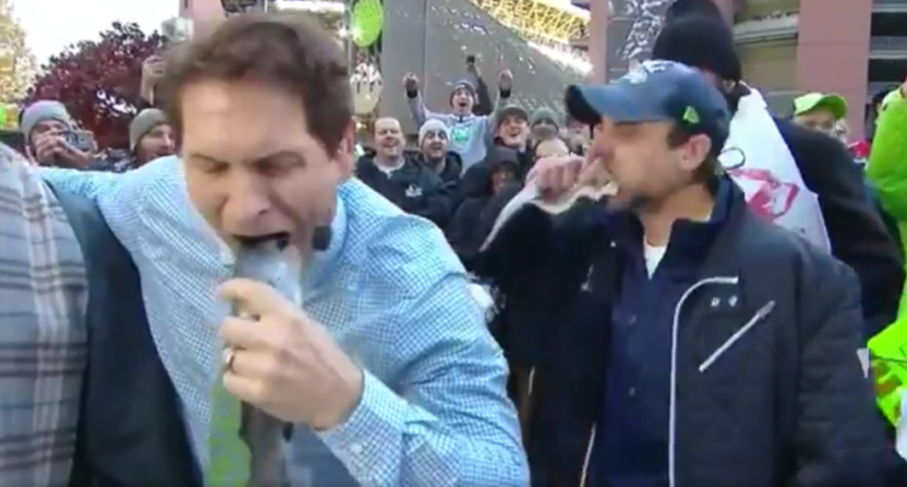 Steve Young chomping down on the head of a raw fish.