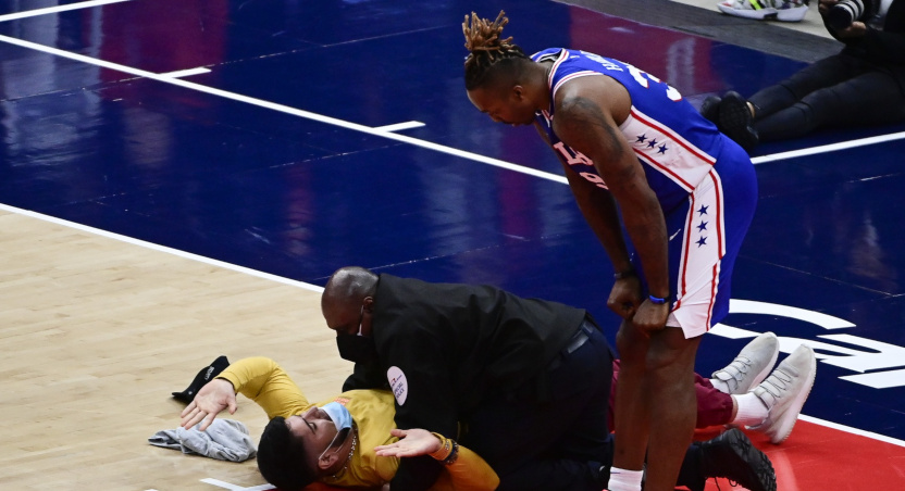 A security guard pins a fan who invaded the court as Dwight Howard looks on.