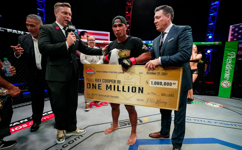 PFL CEO Peter Murray (right) hands men's welterweight champion Ray Cooper III a $1 million check.