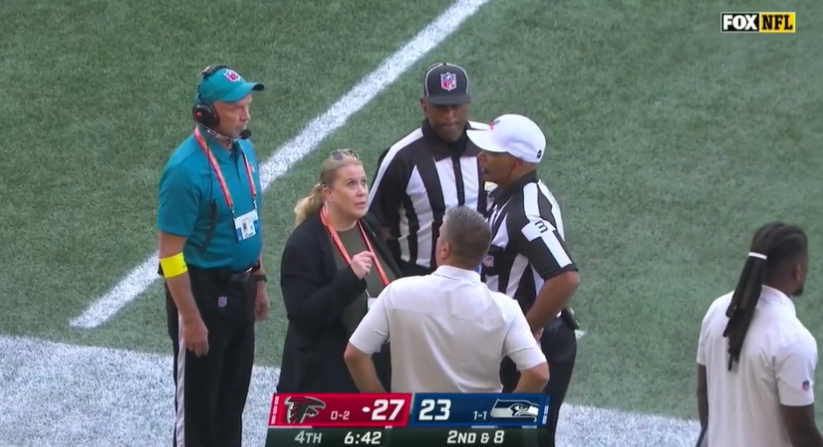 NFL officials converse during another drone delay in Seattle.