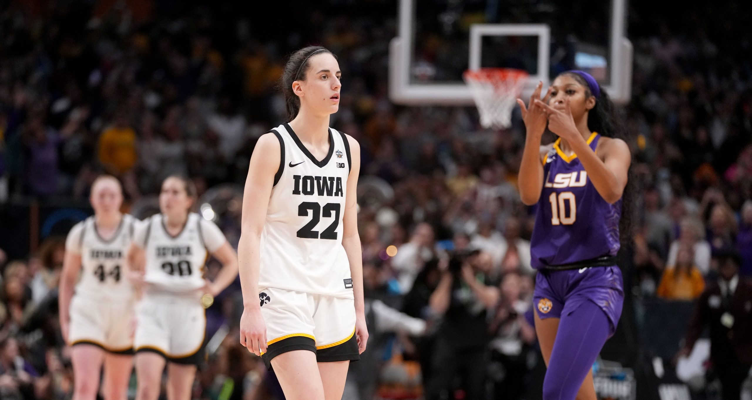 LSU forward Angel Reese (10) shows Iowa guard Caitlin Clark (22) her ring finger