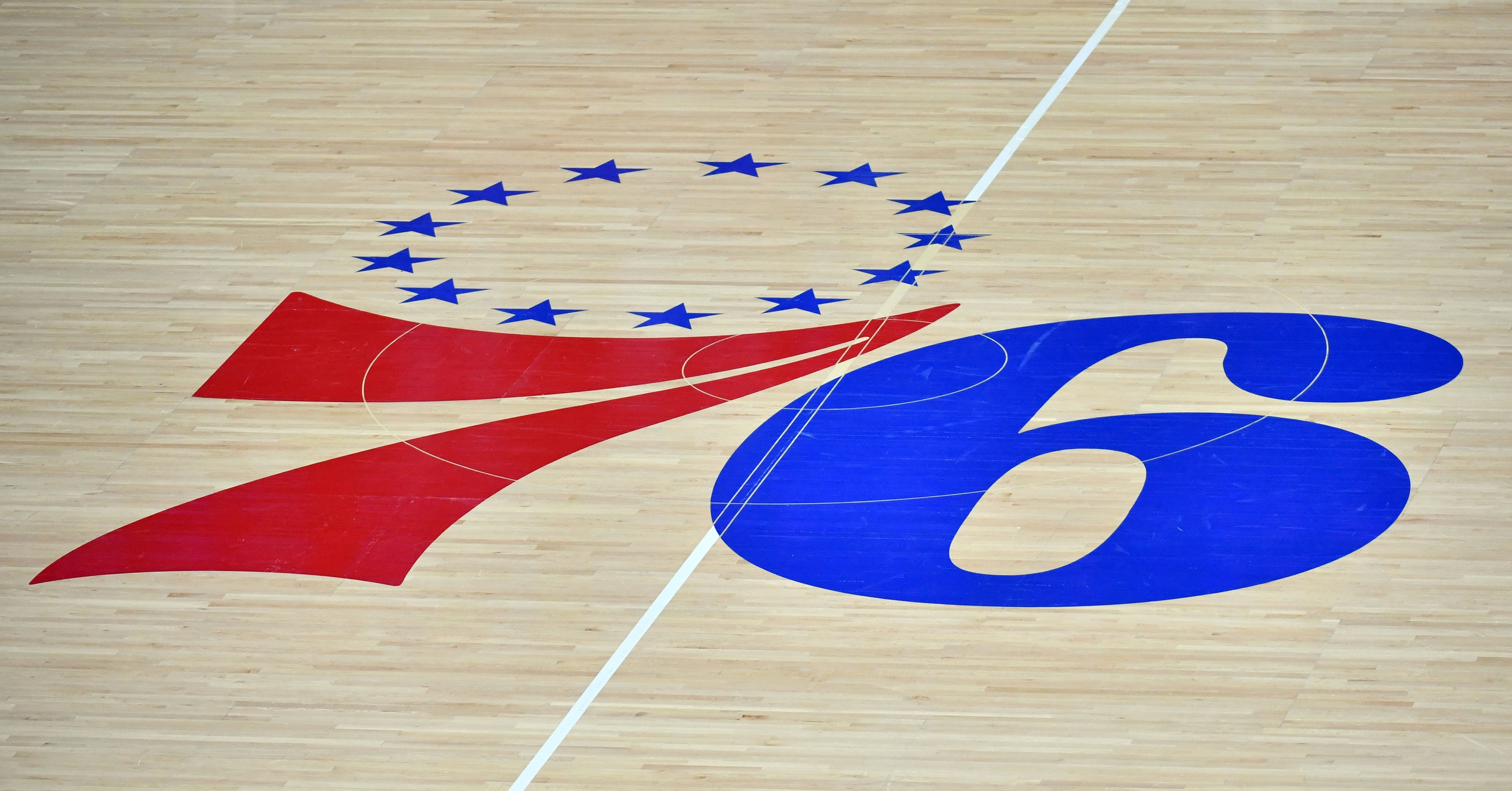 Philadelphia 76ers logo on the hardwood court against the San Antonio Spurs at Wells Fargo Center.