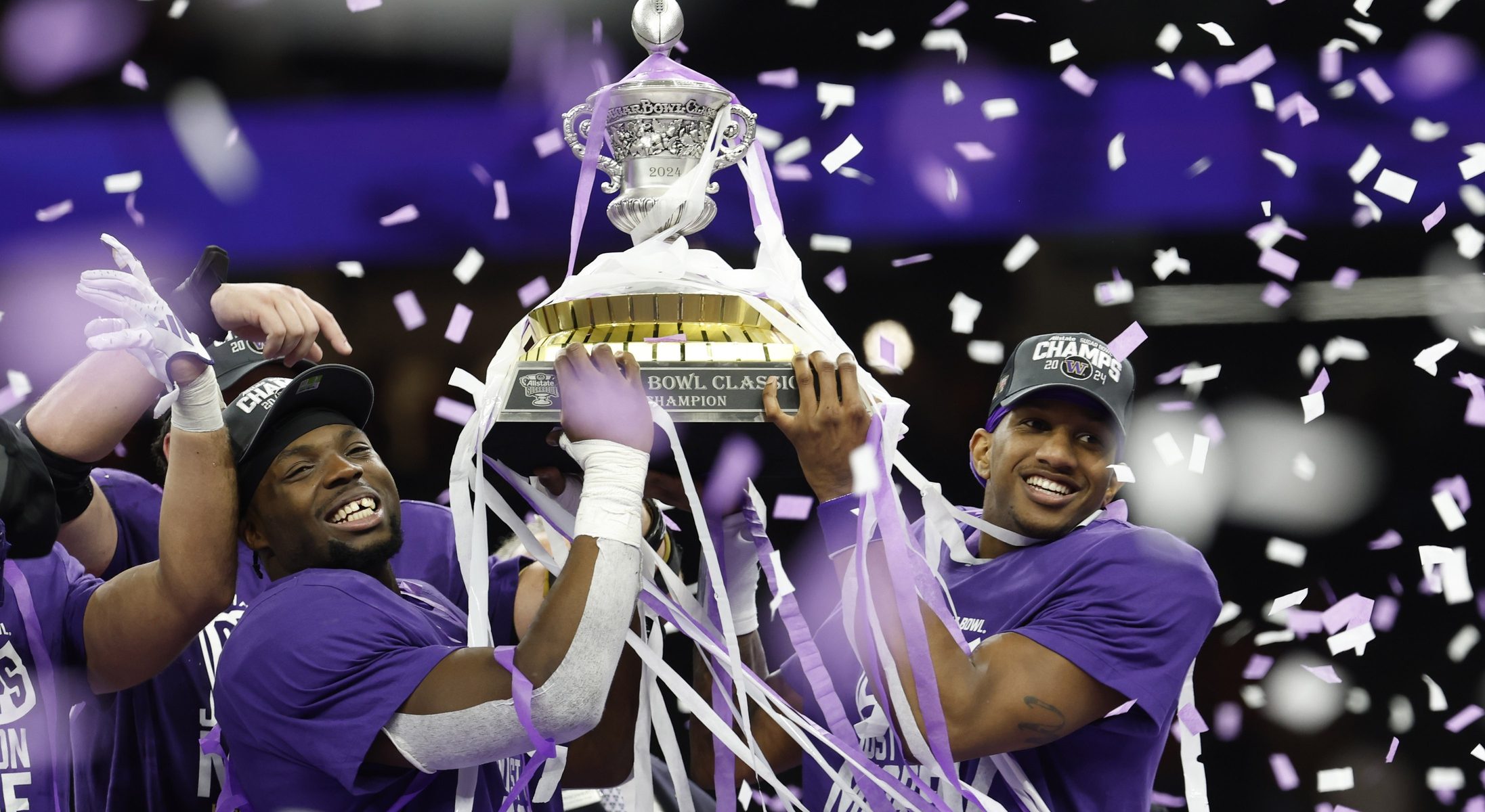 Jan 1, 2024; New Orleans, LA, USA; Washington Huskies quarterback Michael Penix Jr. (R) celebrates with teammates hoisting the Sugar Bowl Trophy after their game against the Texas Longhorns in the 2024 Sugar Bowl college football playoff semifinal game at Caesars Superdome. Mandatory Credit: Geoff Burke-USA TODAY Sports