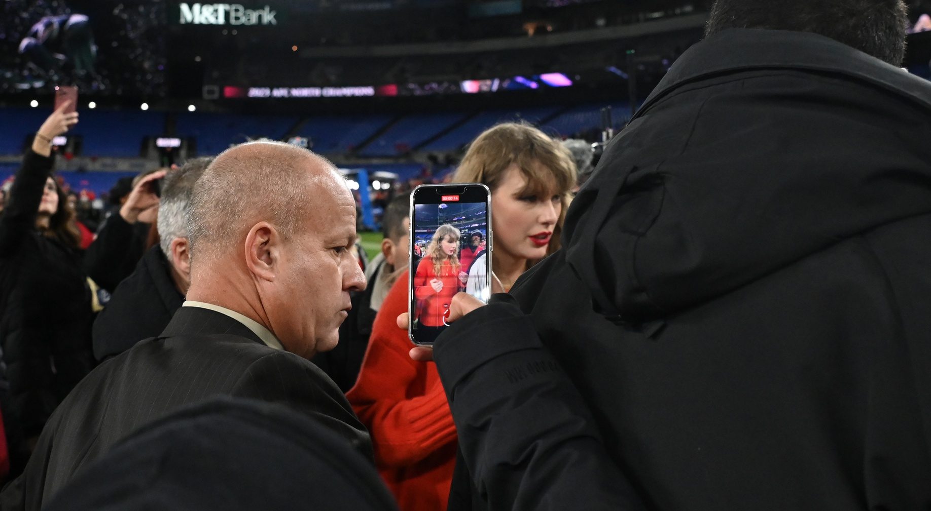Jan 28, 2024; Baltimore, Maryland, USA; A fan takes a photo of American singer-songwriter Taylor Swift (center) walks off the field after the Kansas City Chiefs won the AFC Championship football game against the Baltimore Ravens at M&T Bank Stadium.