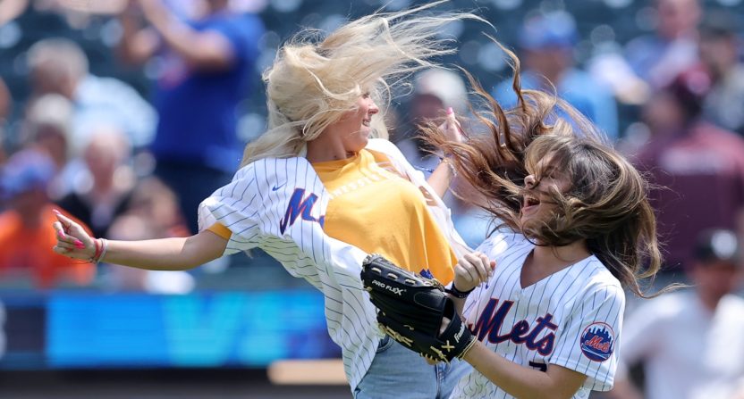 Viral internet star Haliey Welch (left) celebrates with a friend after throwing out a ceremonial first pitch before a game between the New York Mets and the Oakland Athletics
