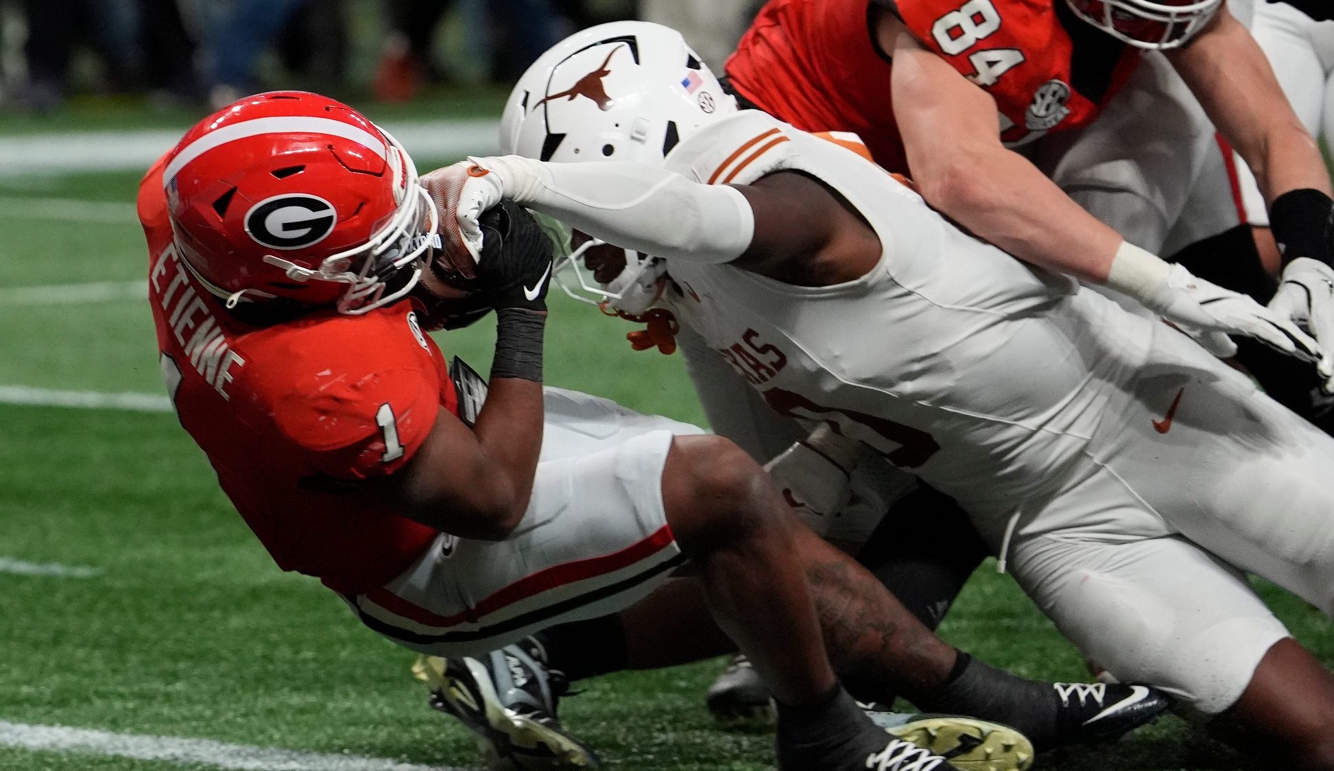Georgia running back Trevor Etienne (1) powers past Texas linebacker Anthony Hill Jr. (0) to score the game winning touchdown during overtime of the SEC championship game against Texas in Atlanta, on Saturday, Dec. 7, 2024.