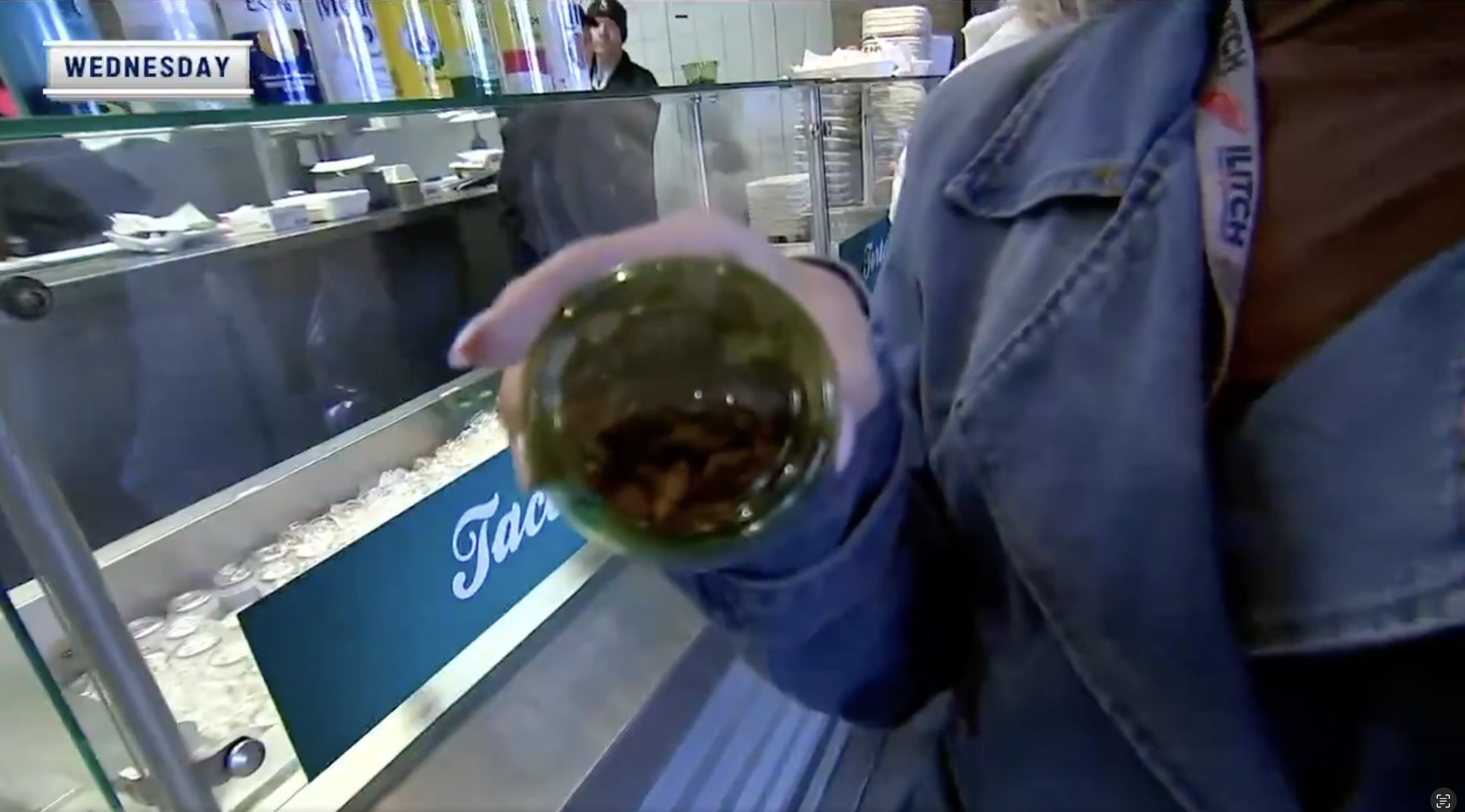 Tigers on-field reporter Daniella Bruce holding a bowl of grasshoppers from T-Mobile Field in Seattle