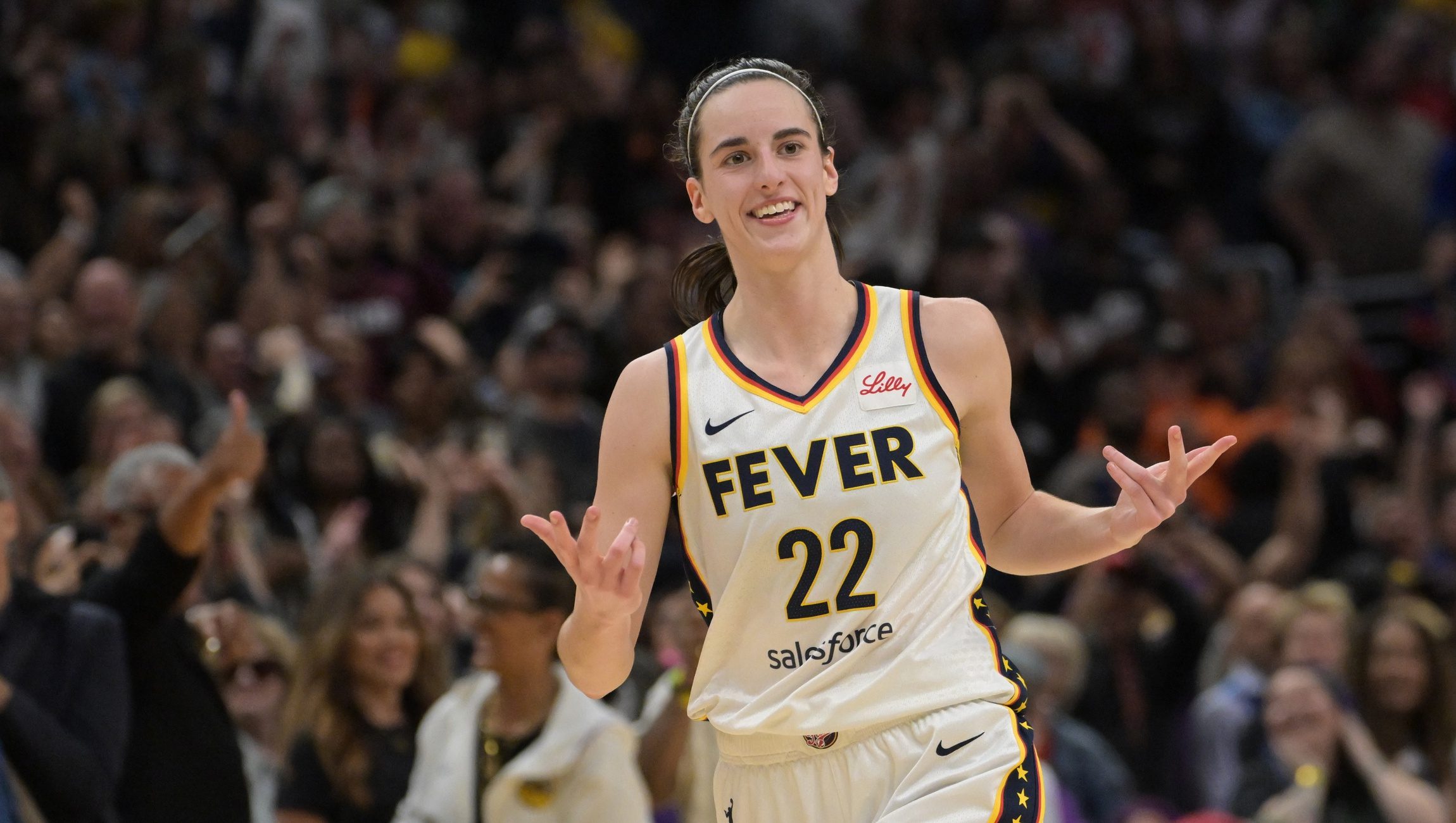 Indiana Fever guard Caitlin Clark (22) smiles as she heads down court after a 3-point basket in the final seconds of the game against the Los Angeles Sparks at Crypto.com Arena.