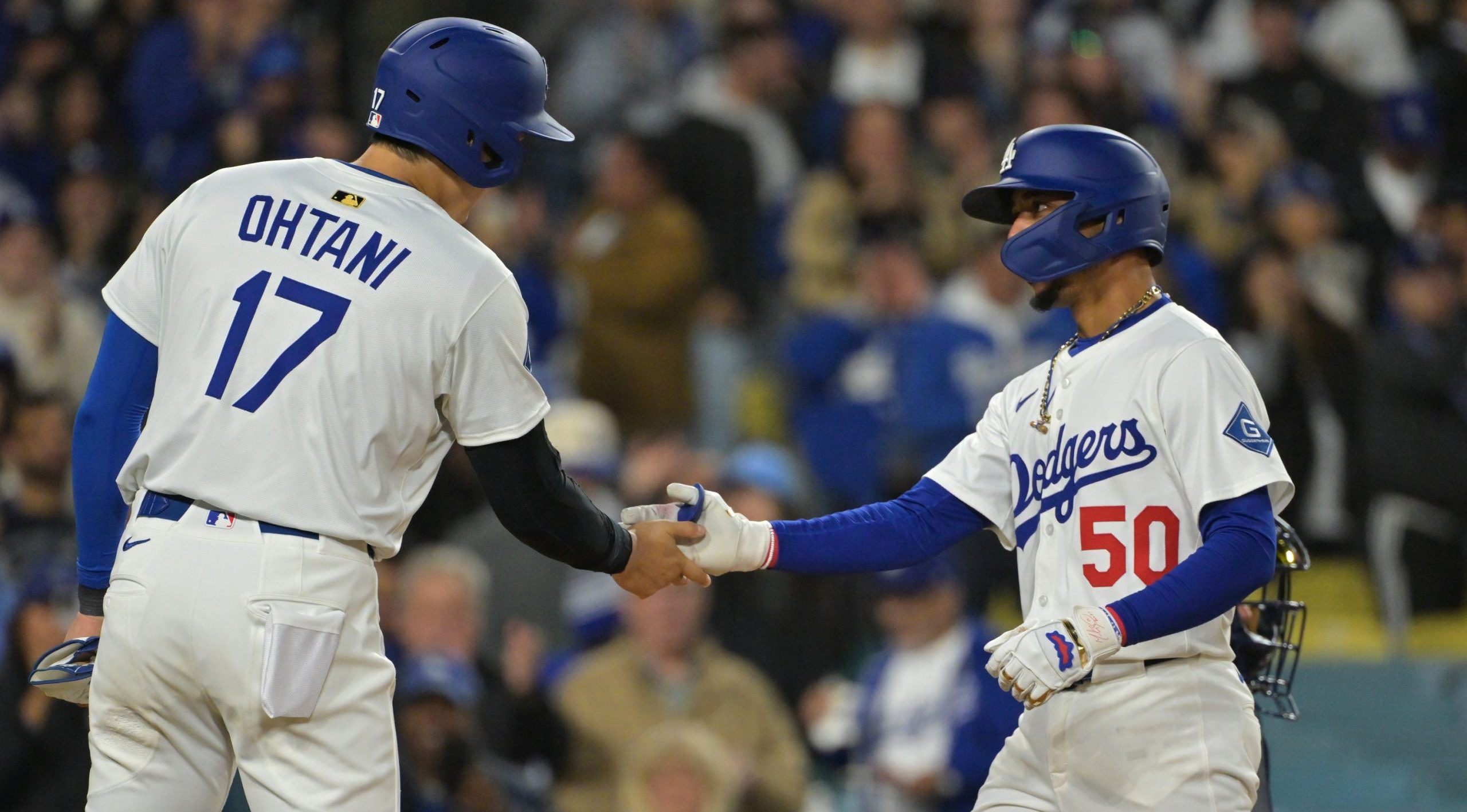 Apr 1, 2025; Los Angeles, California, USA; Los Angeles Dodgers shortstop Mookie Betts (50) shakes hands with designated hitter Shohei Ohtani (17) after hitting a two run home run in the sixth inning against the Atlanta Braves at Dodger Stadium. Mandatory Credit: Jayne Kamin-Oncea-Imagn Images