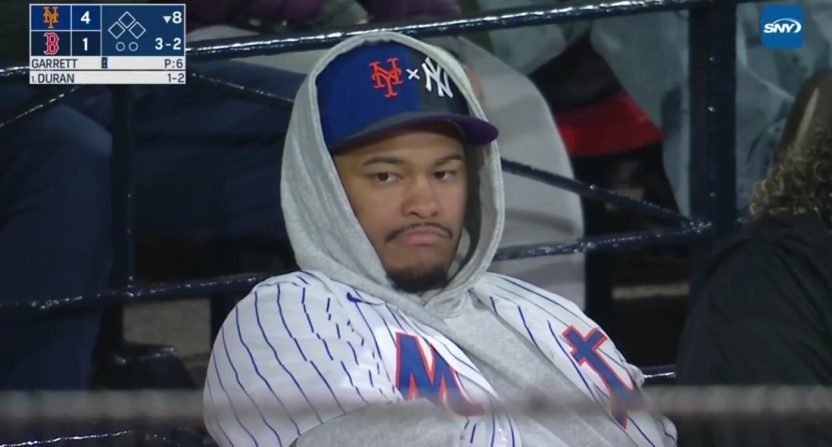 A fan watches a Mets-Red Sox game as SNY's Gary Cohen criticizes hit Yankees-Mets split hat. Photo Credit: SNY