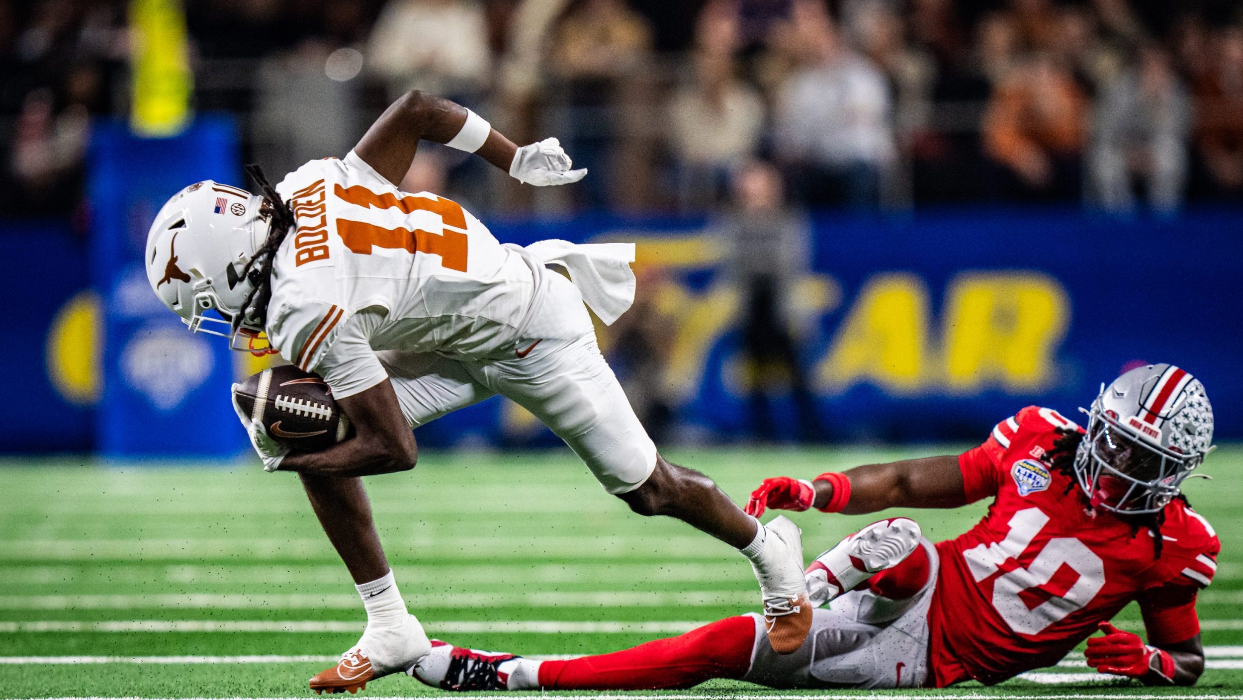 Texas Longhorns wide receiver Silas Bolden (11) runs out of a tackle from Ohio State Buckeyes cornerback Denzel Burke (10) in the second quarter as the Texas Longhorns play the Ohio State Buckeyes in the Cotton Bowl College Football Playoff semi-final at AT&T Stadium in Dallas, Texas, Jan. 10, 2025.