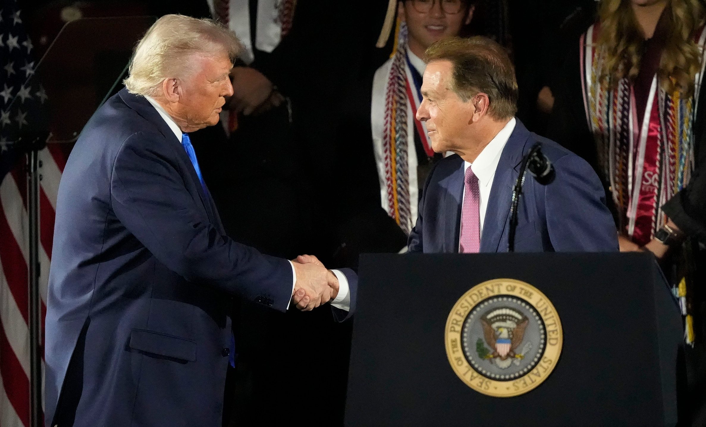 President Donald Trump shakes hands with legendary Alabama football coach Nick Saban before delivering a special commencement address to University of Alabama graduates at Coleman Coliseum on May 1, 2025. Graduation occurs over the weekend.
