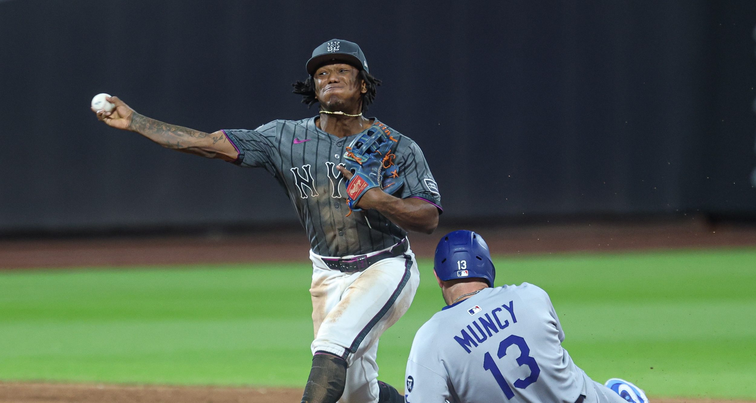 May 25, 2025; New York City, New York, USA; New York Mets second baseman Luisangel Acuna (2) attempts to turn a double play after forcing out Los Angeles Dodgers third baseman Max Muncy (13) at second base during the ninth inning at Citi Field