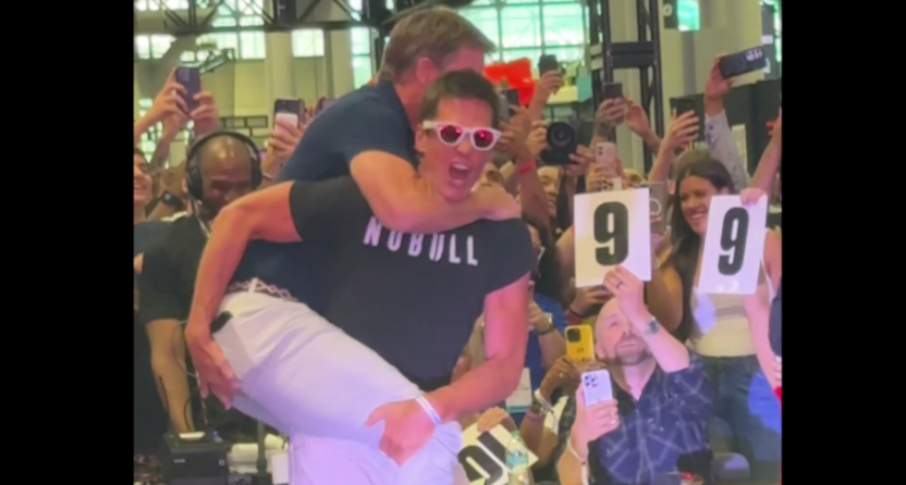 Eli Manning jumps on Tom Brady during a wrestling bit at FanaticsFest NYC on June 20, 2025.