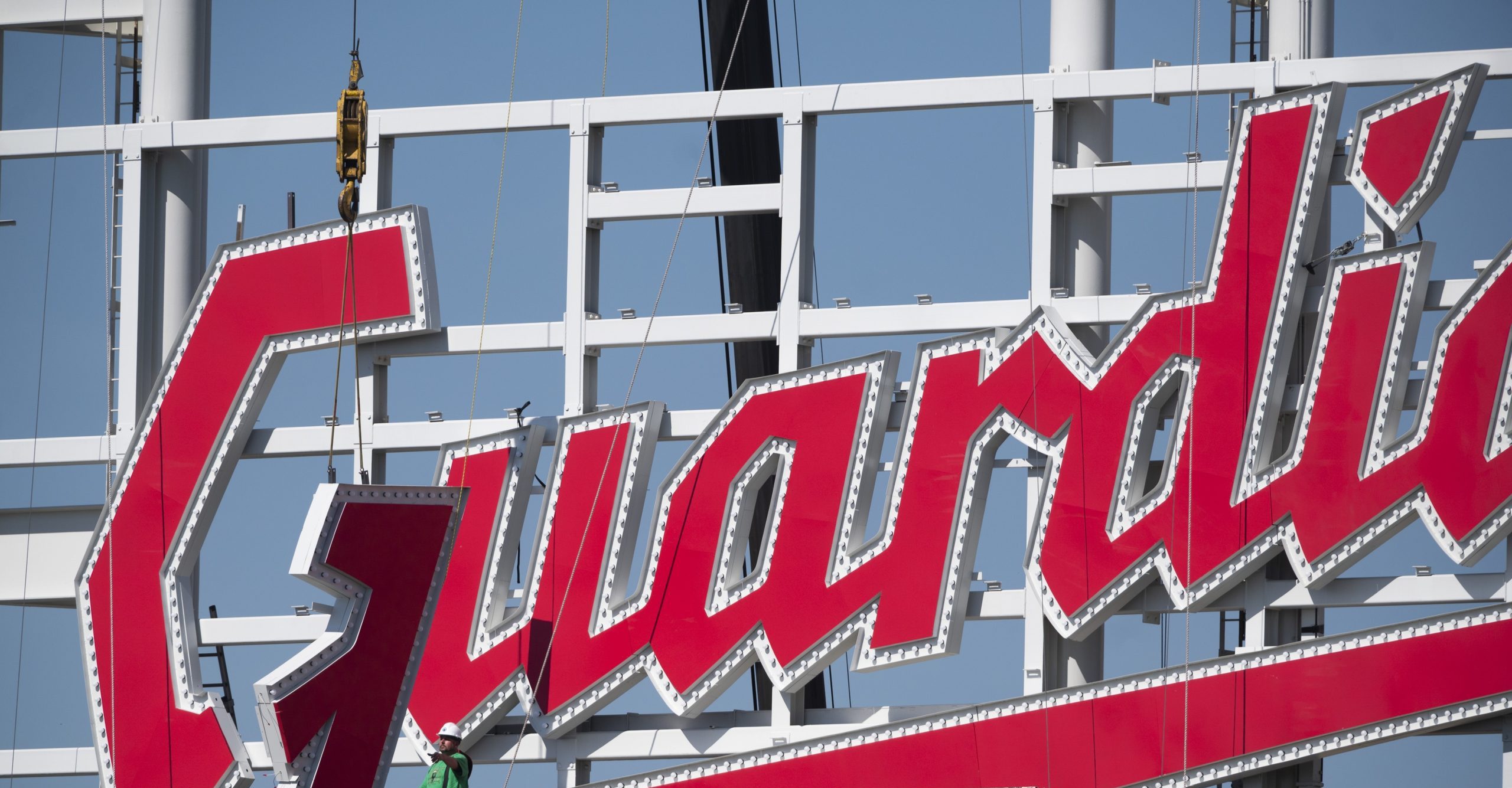 Workers from the Brilliant Electric Sign Company install the final letter to the new Cleveland Guardians sign on the scoreboard at Progressive Field.