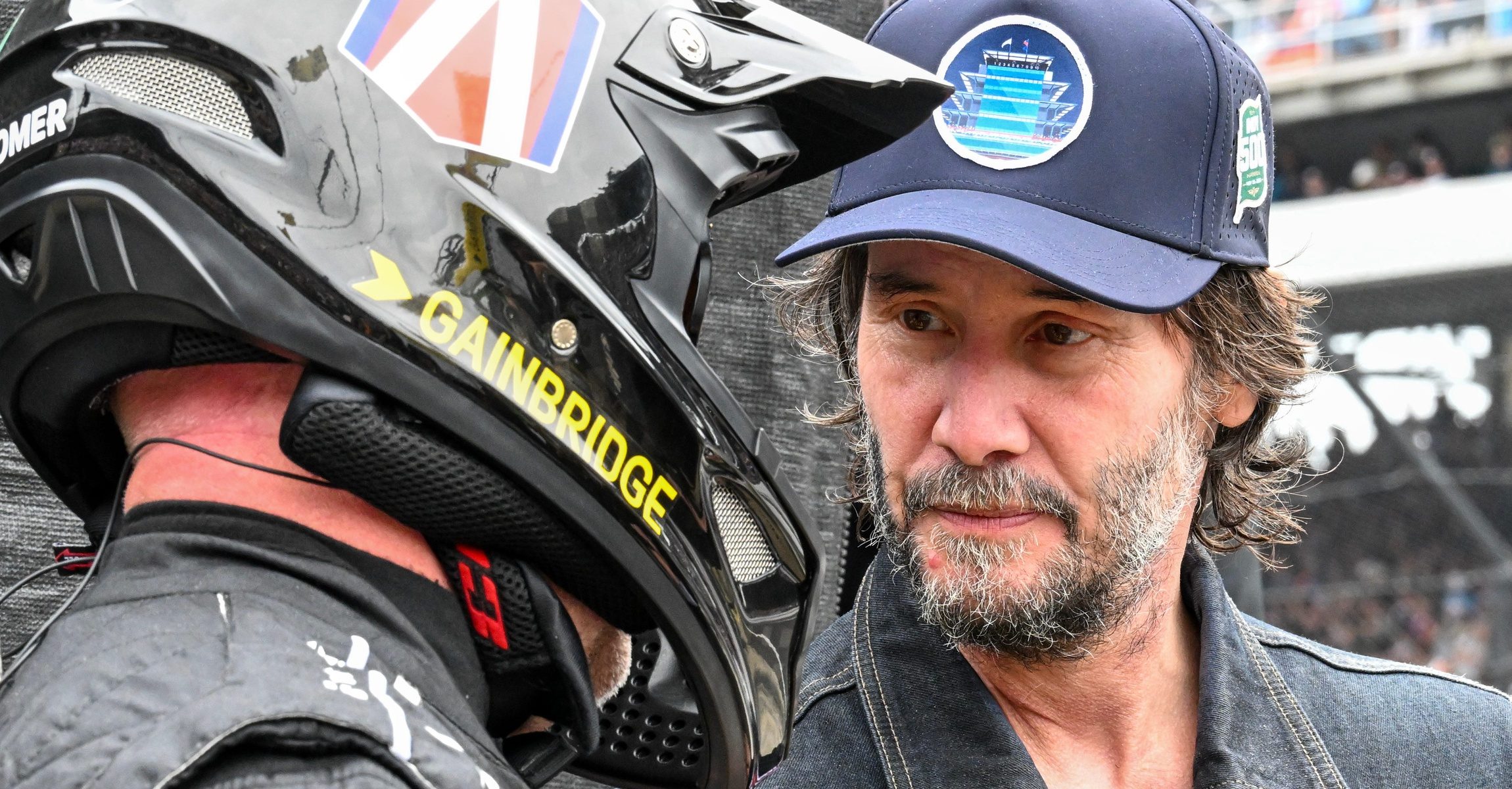 Keanu Reeves talks to a crewmember in Andretti Global with Curb-Agajanian driver Colton Herta’s (26) pit area on Sunday, May 25, 2025, during the 109th running of the Indianapolis 500 at Indianapolis Motor Speedway.