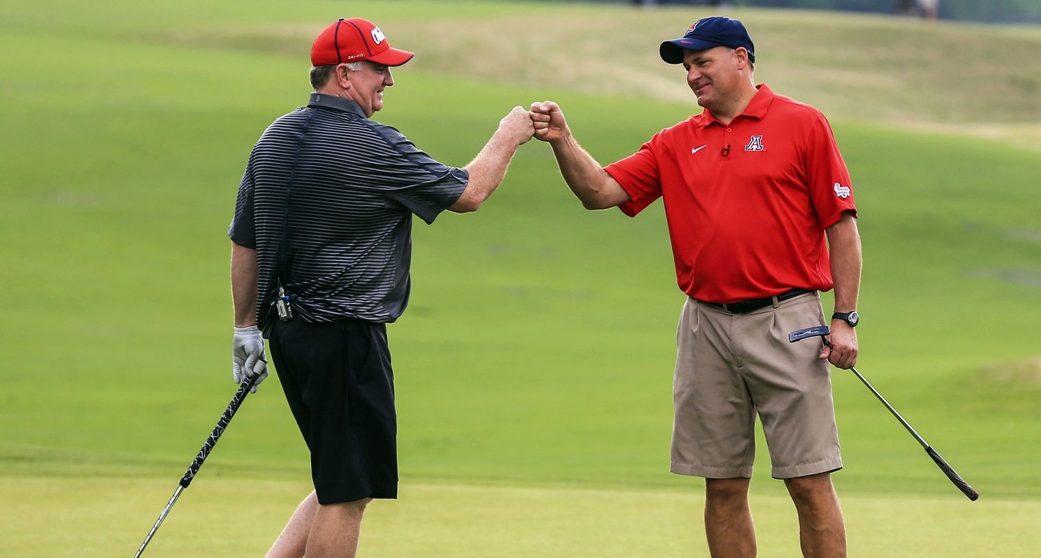 Mississippi Rebels head football coach Hugh Freeze (left) celebrates finishing play for the day with Arizona head football coach Rich Rodriguez at the Chick-fil-A Challenge at Reynolds Plantation Resort.