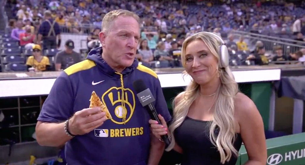 Brewers’ Pat Murphy shares more pocket food with Tricia Whitaker during in-game interview