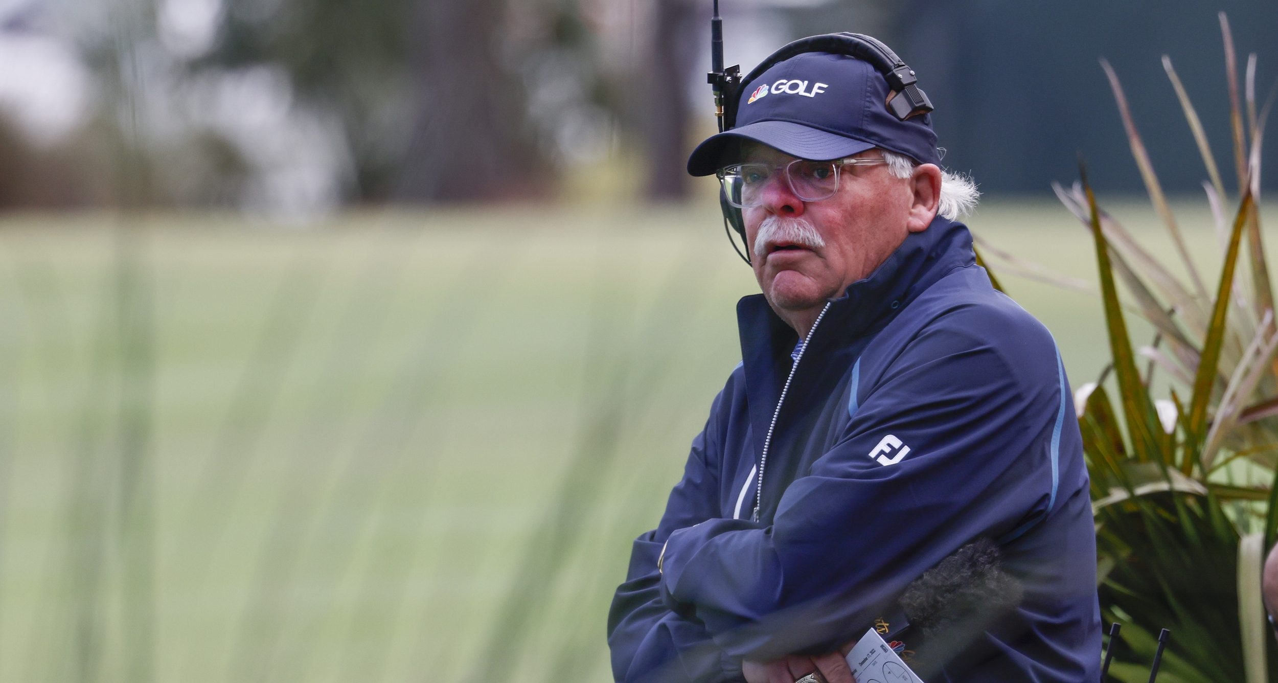 Roger Maltbie watches players tee off