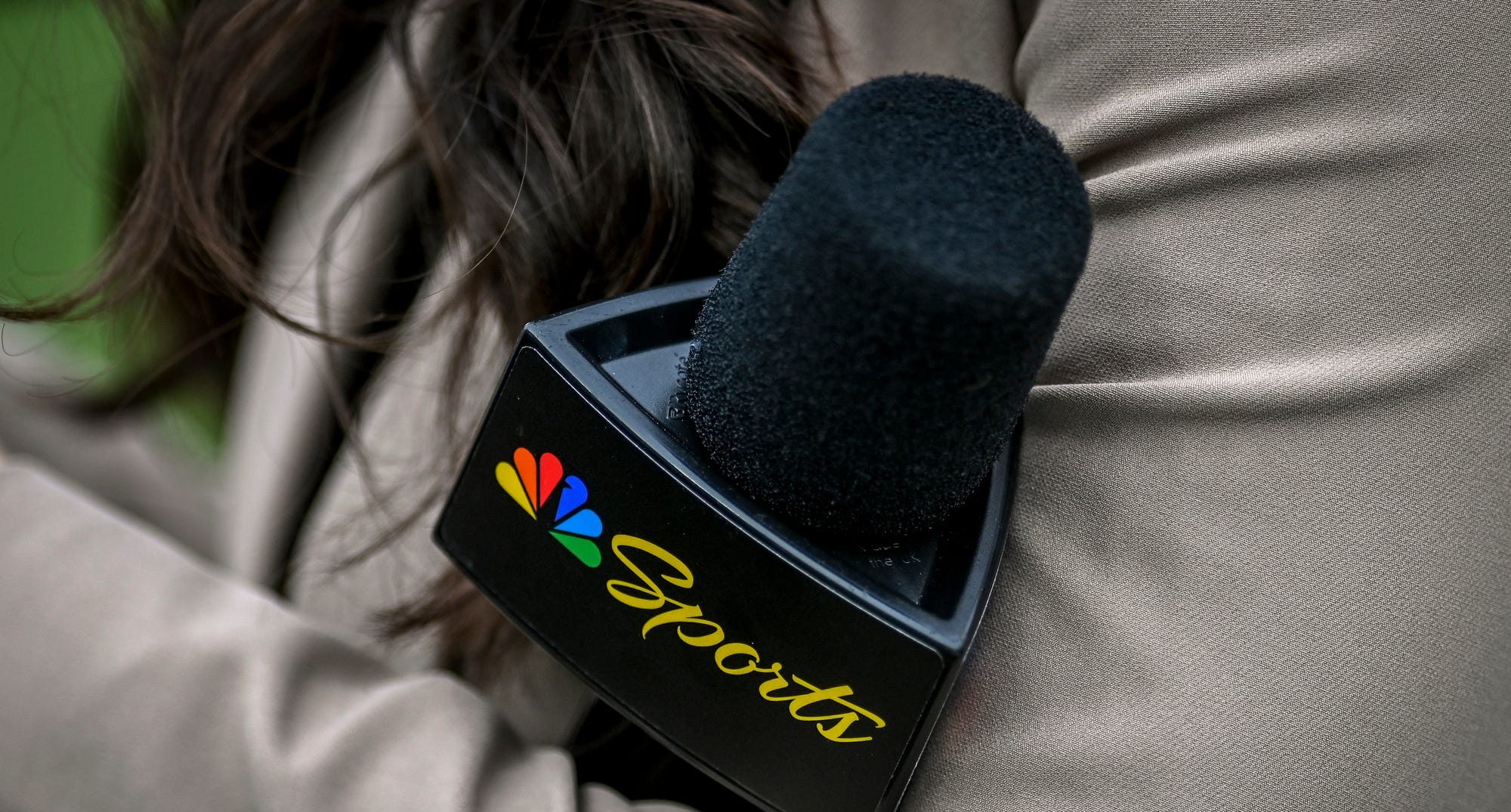 A Peacock sideline reporter holds a microphone with the NBC Peacock logo during Michigan State's football game against Washington on Saturday, Sept. 16, 2023, at Spartan Stadium in East Lansing.