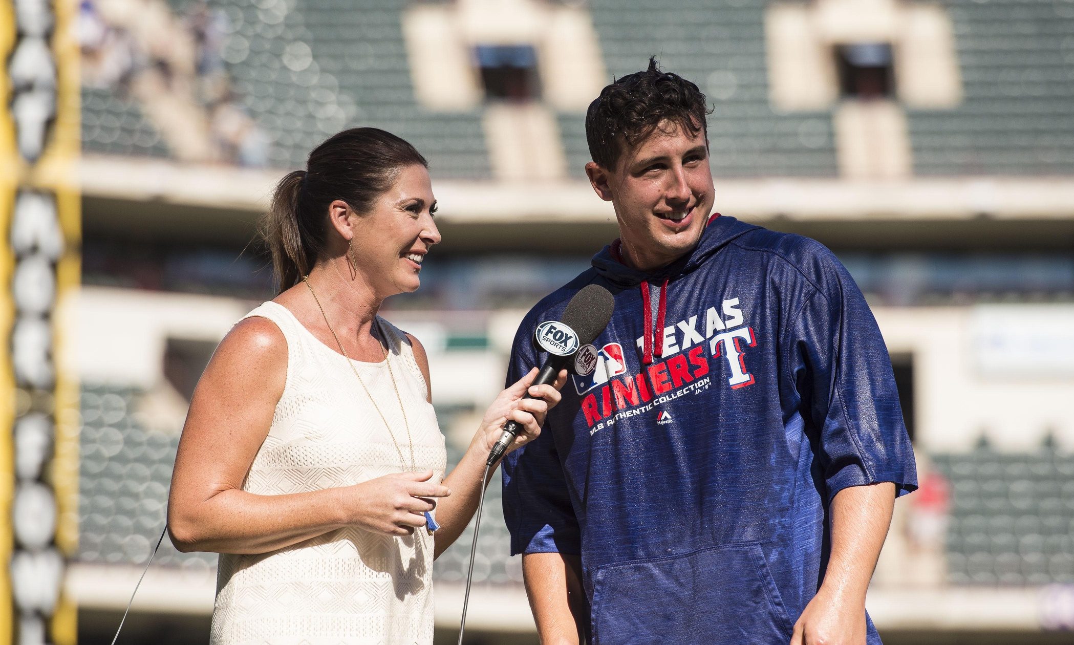 Texas Rangers starting pitcher Derek Holland (45) is interviewed by Emily Jones (L) after defeating the Cleveland Indians 2-1 at Globe Life Park in Arlington.