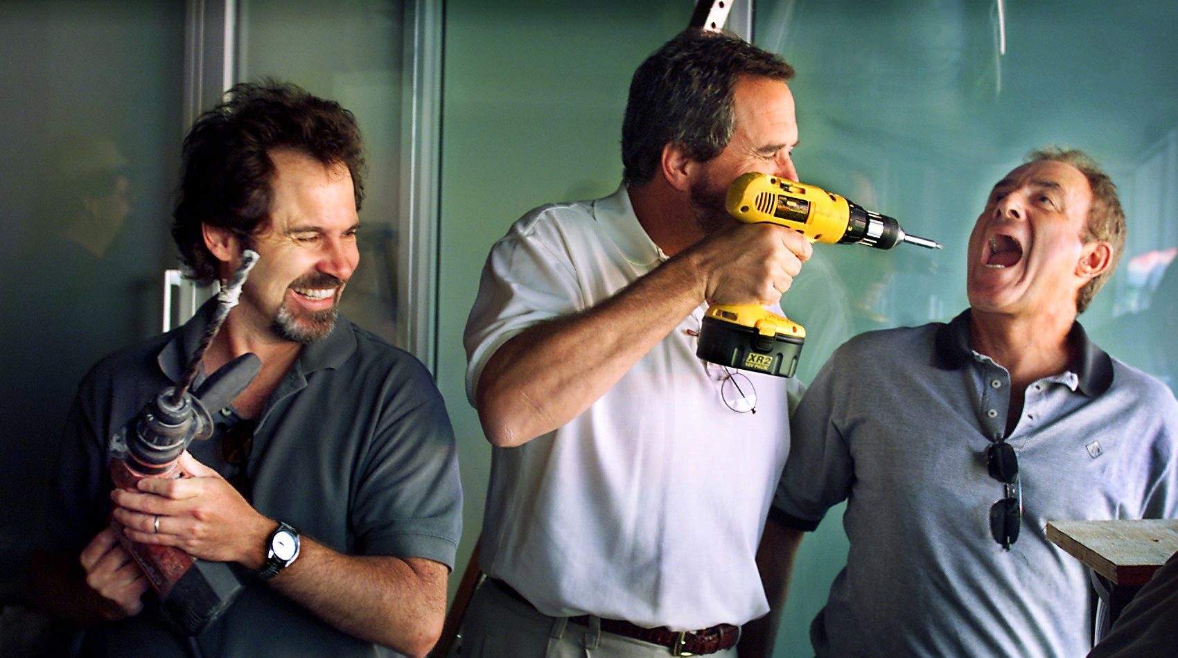 "Monday Night Football" announcers Dennis Miller, left, Dan Fouts and Al Michaels joke around with power tools in the press booth of Adelphia Coliseum on Aug. 13, 2000. The anchors showed up to check out the press booth where they will be announcing the next night's game between the Tennessee Titans and the St. Louis Rams.
