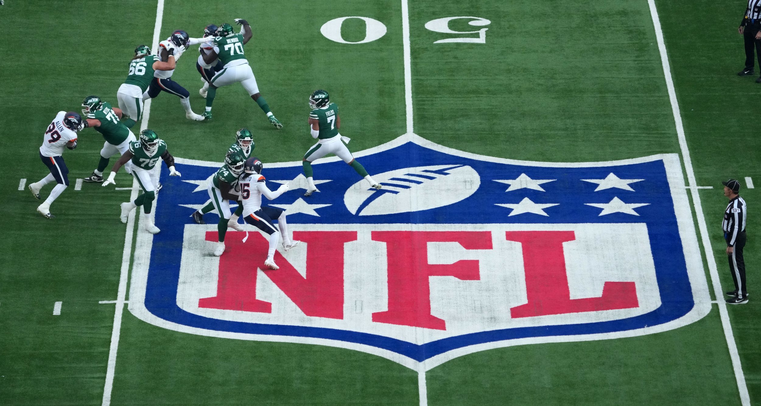 A general overall view as New York Jets quarterback Justin Fields (7) throws the ball at midfield on the NFL shield logo