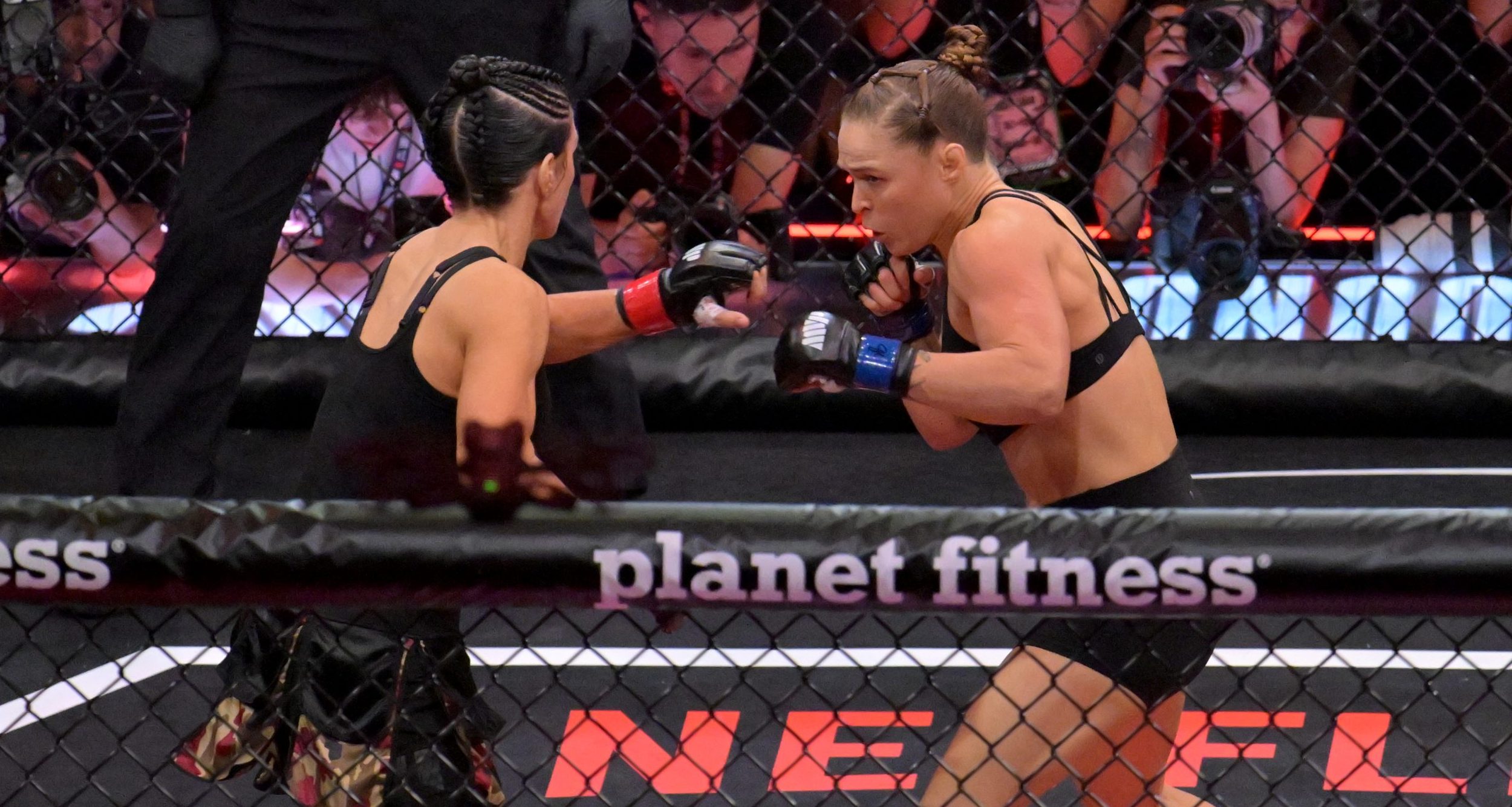 Ronda Rousey (blue gloves) fights Gina Carano (red gloves)