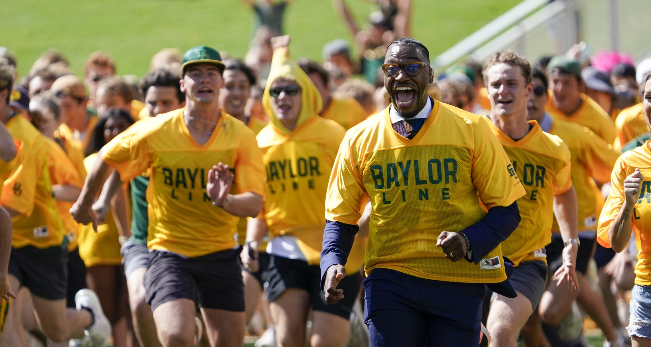 Former Baylor quarterback and Heisman Trophy winner Robert Griffin III runs with the Baylor Line prior to a game between the Baylor Bears and the Utah Utes at McLane Stadium.